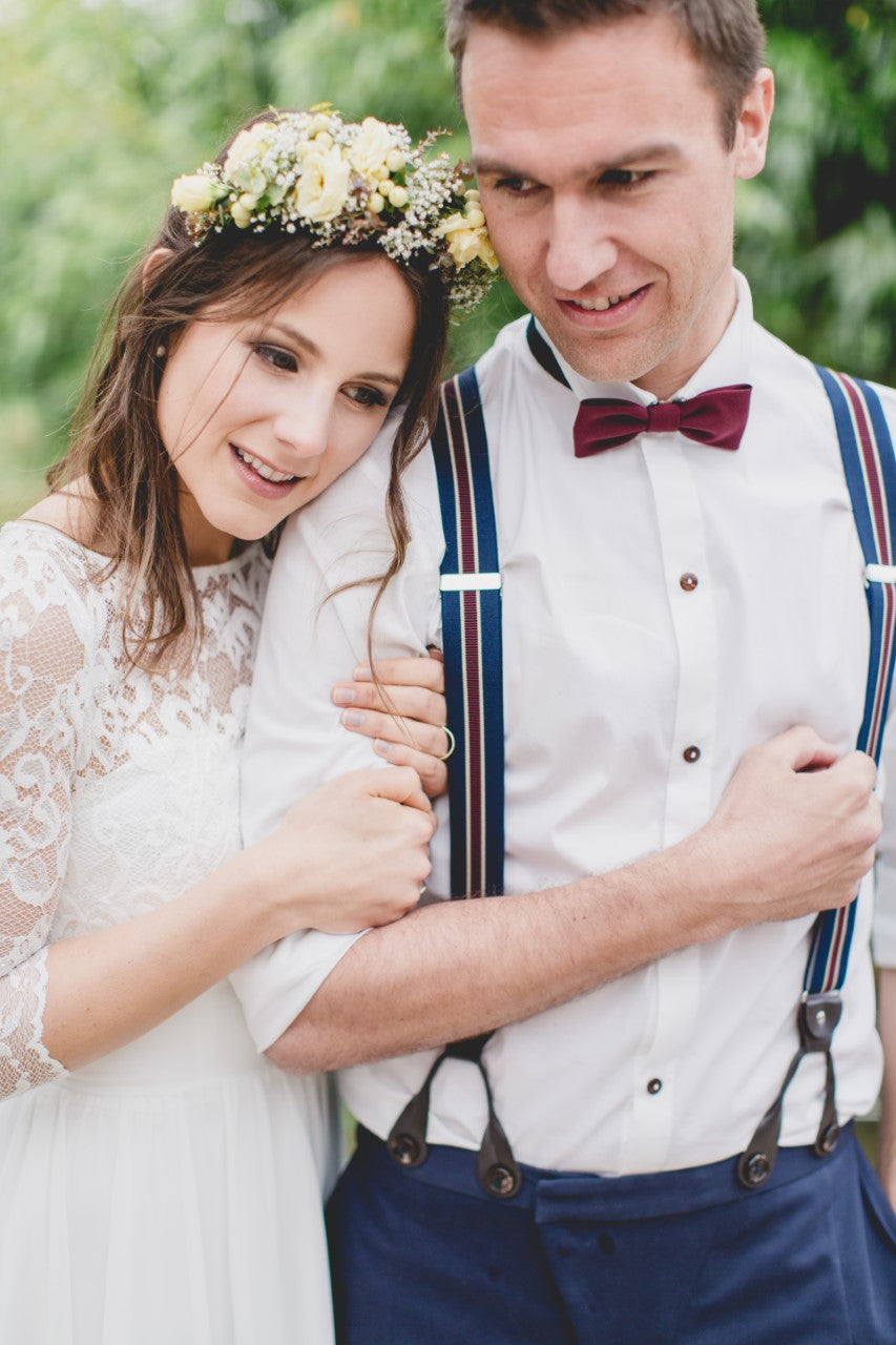 Hochzeitspaar, der Bräutigam trägt einen Massanzug und handgefertigte Hosenträger und Fliege