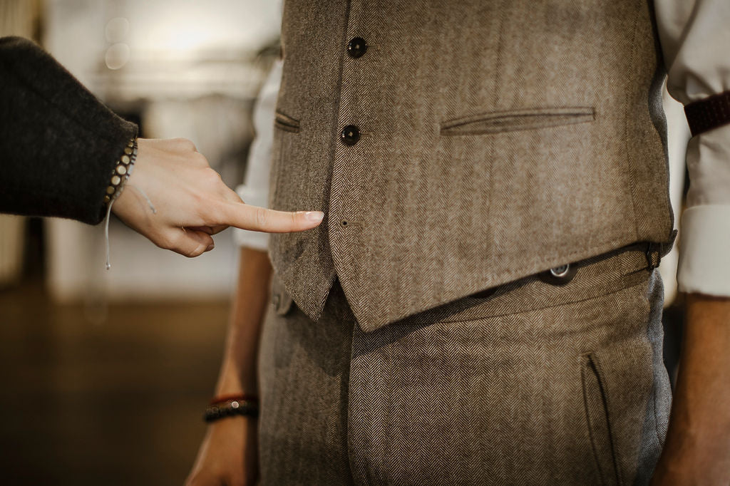 Schneiderin zeigt mit Finger auf ein Gilet, das Massangefertigt wurde